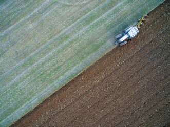 Italy, Umbria, Gubbio, Aerial view of a tractor working in the fields - LOMF00667