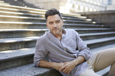 Portrait of serious mature man sitting on stairs - PNEF00310