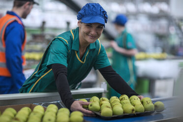 Porträt einer lächelnden Frau, die in einer Apfelfabrik arbeitet - ZEF14703