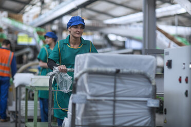 Woman pushing cart in factory - ZEF14707