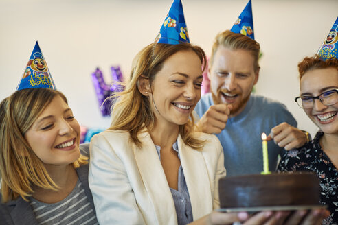 Kollegen feiern Geburtstag im Büro mit Kuchen und Partyhüten - ZEDF00981