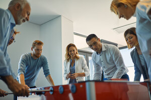 Kollegen spielen Tischfußball im Büro - ZEDF00985