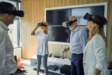 Colleagues wearing VR glasses in office - ZEDF00991