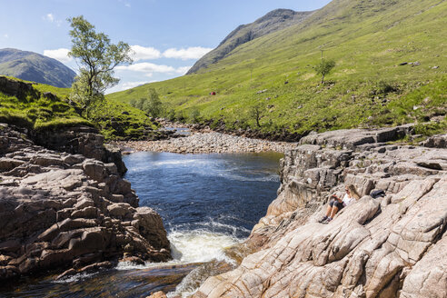 Großbritannien, Schottland, Schottische Highlands, Glen Etive mit dem Fluss Etive und den Glen Etive Falls, weibliche Touristin beim Lesen - FOF09431