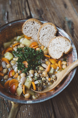 Mediterranean soup and bread slices in copper pot stock photo