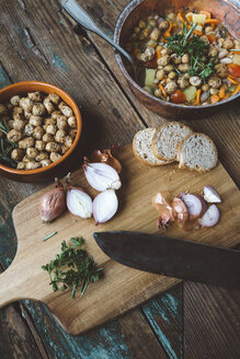 Mediterrane Suppe in Kupfertopf, Schale mit Croutons und Zutaten auf Holzbrett - GIOF03291