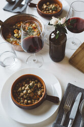 Gedeckter Tisch mit mediterraner Suppe und Rotwein - GIOF03303