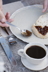 Italien, Frau frühstückt mit Brot mit Marmelade auf Terrasse, Teilansicht - ALBF00223