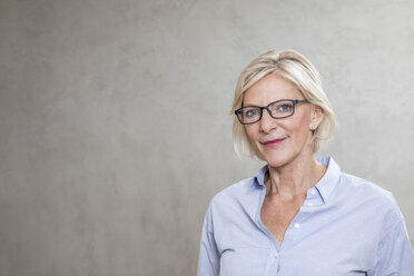 Portrait of smiling senior woman wearing glasses - FMKF04623