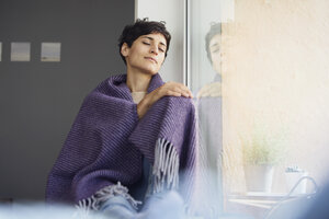 Relaxed woman at home sitting at the window - RBF06103