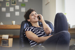 Glückliche Frau, die zu Hause mit ihrem Handy telefoniert - RBF06116