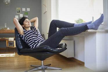 Smiling woman sitting at home relaxing - RBF06119