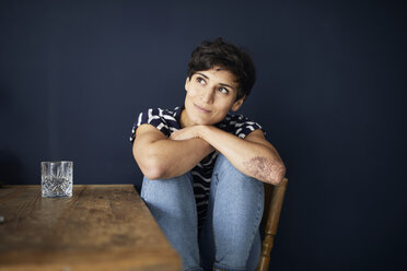 Portrait of woman at home sitting at wooden table - RBF06143