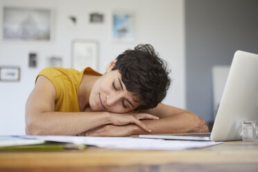 Woman at home resting on table with laptop - RBF06151