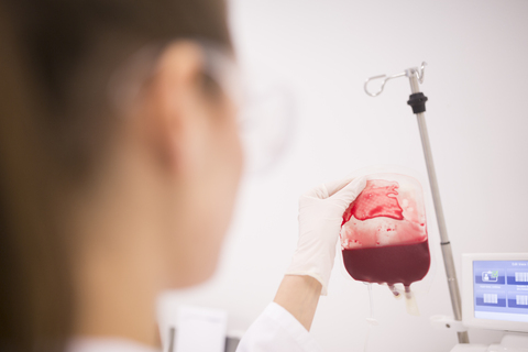 Wissenschaftlerin bei der Arbeit mit Blutbeutel im Labor, lizenzfreies Stockfoto