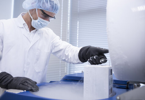 Scientist in lab storing biological material in cryo store - WESTF23632