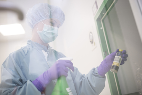 Laborantin hält Flasche und Sprühflasche im Labor, lizenzfreies Stockfoto