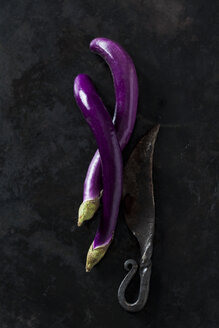 Zwei Perlina-Auberginen und ein altes Messer auf dunklem Grund - CSF28503