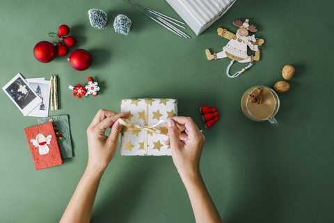 Frauenhände verpacken Weihnachtsgeschenk, lizenzfreies Stockfoto