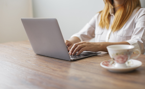 Geschäftsfrau arbeitet am Laptop am Schreibtisch im Büro, Teilansicht, lizenzfreies Stockfoto