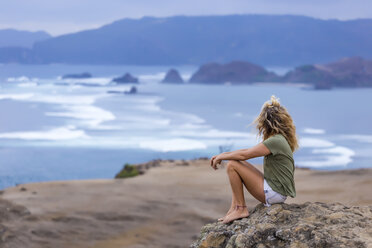 Indonesia, Lombok, woman sitting at the coast looking at view - KNTF00909