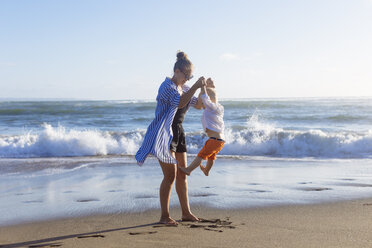 Indonesien, Bali, Mutter und Sohn spielen am Strand - KNTF00912