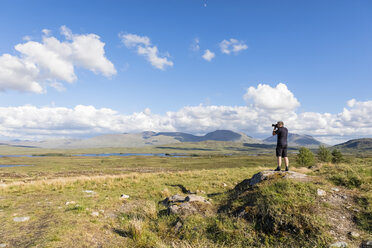 Great Britain, Scotland, Scottish Highlands, Glencoe, Rannoch Moor, Tourist photographing Loch Beinn Chaorach and Loch Ba - FOF09509