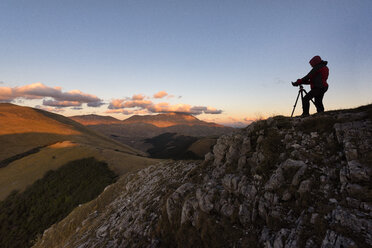 Italien, Umbrien, Parco Nazionale dei Monti Sibillini, Fotograf vor dem Monte Vettore bei Sonnenuntergang - LOMF00673