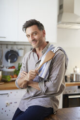 Portrait of smiling man with cooking spoon in the kitchen - PNEF00348