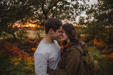 Glückliches verliebtes Paar in herbstlicher Natur bei Sonnenuntergang, lizenzfreies Stockfoto