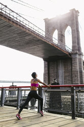 Frau bei Dehnungsübungen in Manhattan in der Nähe der Brooklyn Bridge am Morgen - GIOF03326
