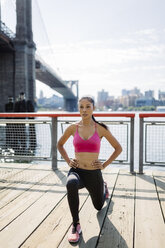 Frau bei Dehnungsübungen in Manhattan in der Nähe der Brooklyn Bridge am Morgen - GIOF03344