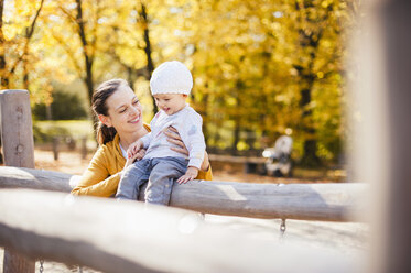 Glückliches kleines Mädchen und ihre Mutter haben Spaß auf einem Spielplatz im Herbst - DIGF03203