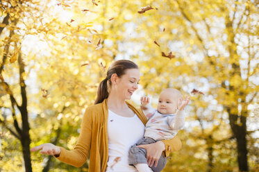 Mutter und kleines Mädchen haben Spaß mit Blättern im Herbst - DIGF03205
