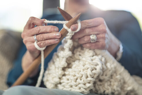 Ältere Frau strickt auf der Couch zu Hause - ZEF14775