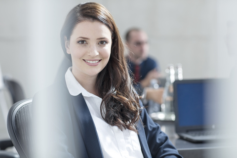 Porträt einer lächelnden Geschäftsfrau bei einem Treffen im Konferenzraum, lizenzfreies Stockfoto