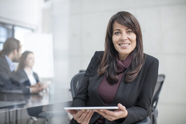 Porträt einer lächelnden Geschäftsfrau mit Tablet auf einer Sitzung im Konferenzraum - ZEF14810