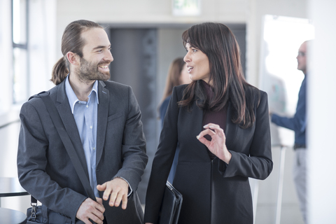 Businessman and businesswoman talking in office stock photo