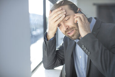 Frustrierter Geschäftsmann im Büro beim Telefonieren - ZEF14822