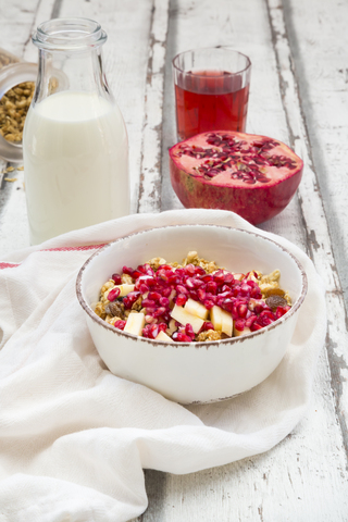 Breakfast with fruit muesli with pomegranate seed, bottle of milk and glass of pomegranate juice stock photo