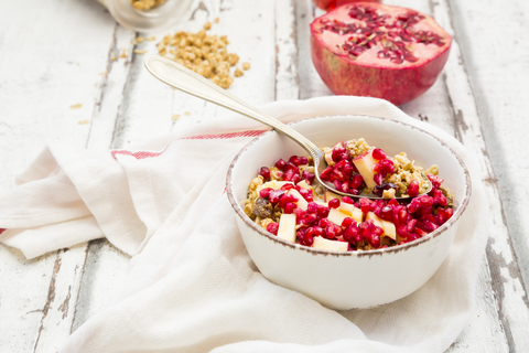 Bowl of fruit muesli with dried cranberries, apple and pomegranate seed stock photo