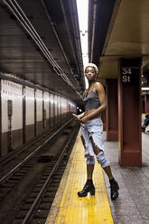 USA, New York City, portrait of woman waiting on subway station platform - MAUF01228