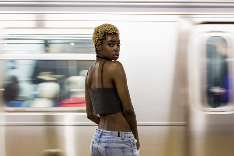 USA, New York City, Porträt einer Frau auf dem Bahnsteig einer U-Bahn-Station, lizenzfreies Stockfoto