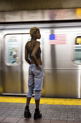 USA, New York City, woman waiting on subway station platform - MAUF01230
