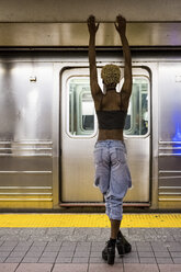 USA, New York City, Rückenansicht einer Frau, die auf dem Bahnsteig einer U-Bahn-Station steht - MAUF01234