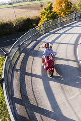 Glückliches junges Paar macht ein Selfie auf einem Motorroller - UUF12287