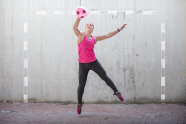 Woman jumping to catch a ball - ZEF14829