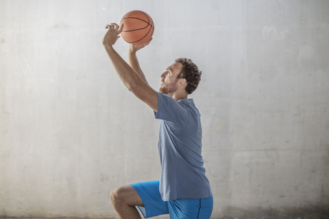 Sportlicher Mann, der einen Basketball wirft, lizenzfreies Stockfoto