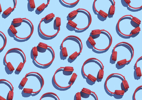 Collection of red wireless headphones on light blue background, 3D Rendering - DRBF00035