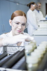 Smiling scientist in lab with samples - WESTF23692